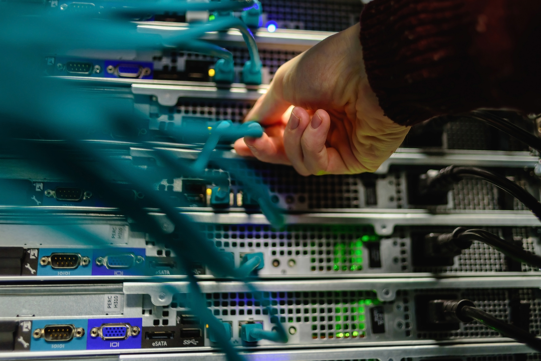 Technician connecting network cables to server equipment